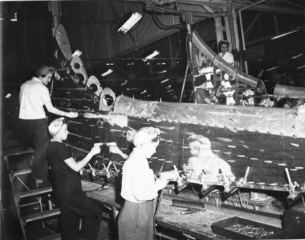 Mujeres construyendo un B-17, mientras los hombres luchan en el frente